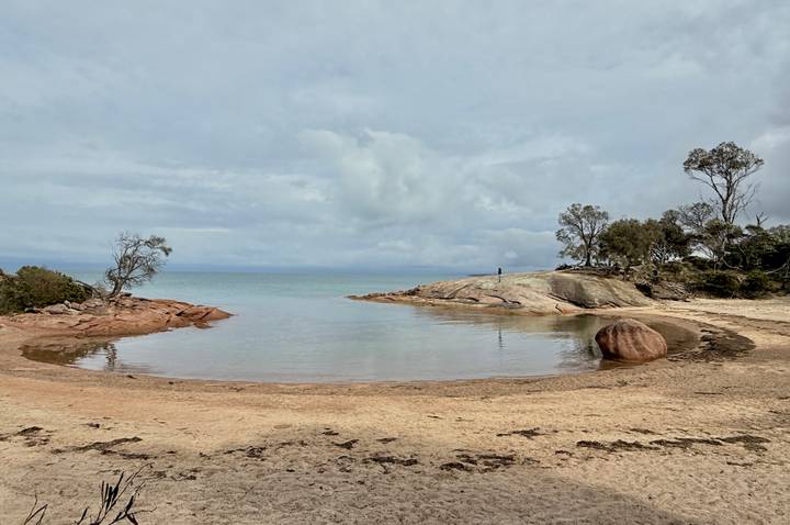 Una bahía serena con aguas tranquilas y costas rocosas.
