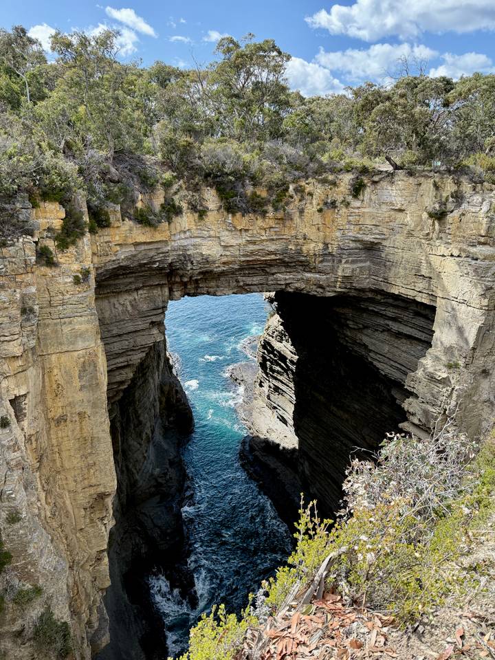 Una formación de arco natural con vista al océano azul.