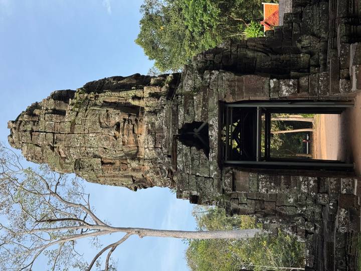 Oude stenen ingang met grote gezichtsuitsnijdingen bij een tempel.