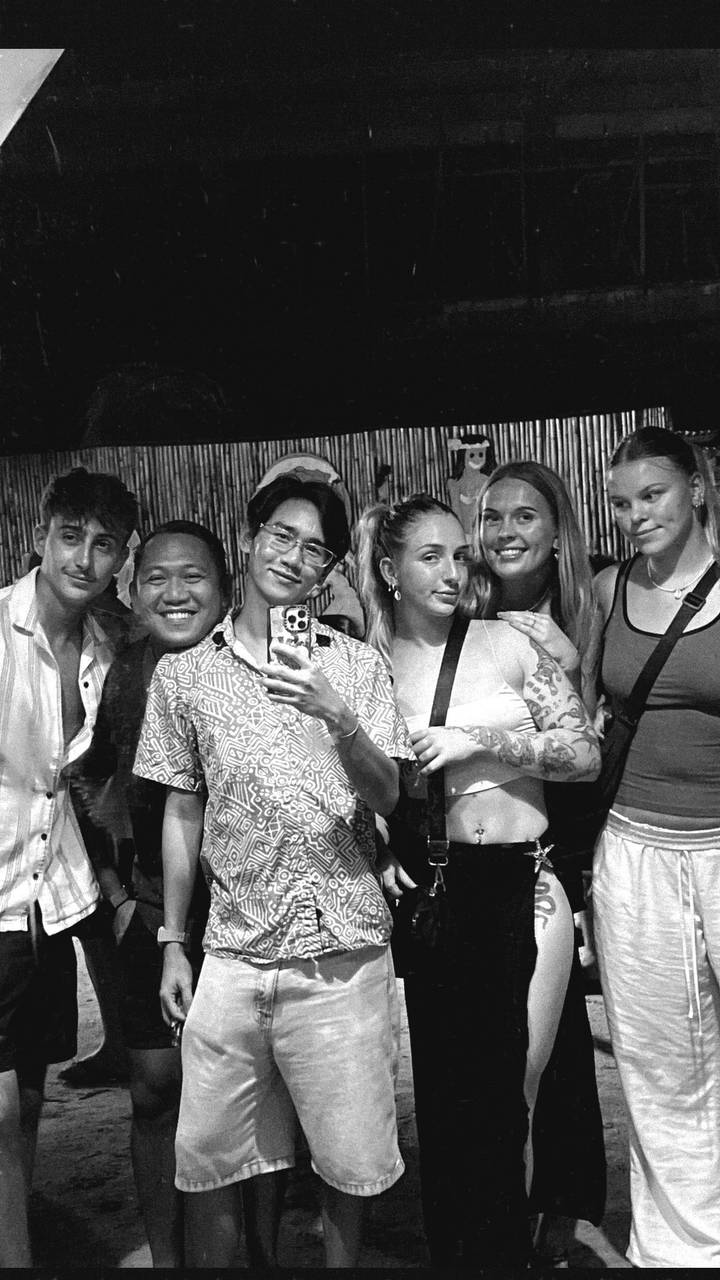 Gruppe von Personen, die in einem gesellschaftlichen Umfeld ein Selfie macht.