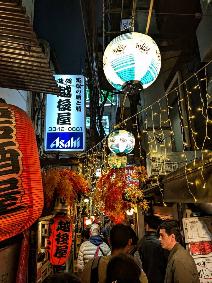 Calle estrecha con farolas y luces de cadena.