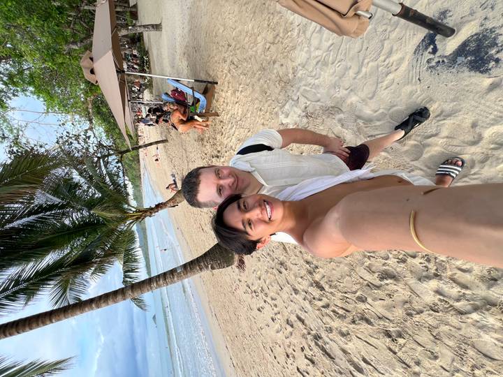 Zwei Personen machen ein Selfie am Strand.