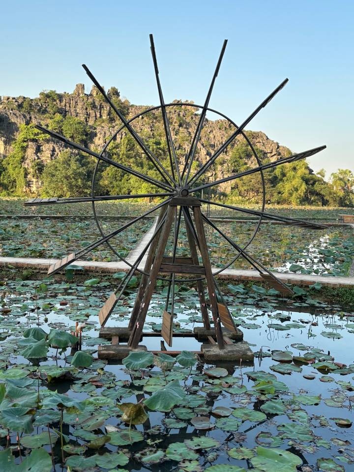 Ein traditionelles Wasserrad in einer üppigen Landschaft.