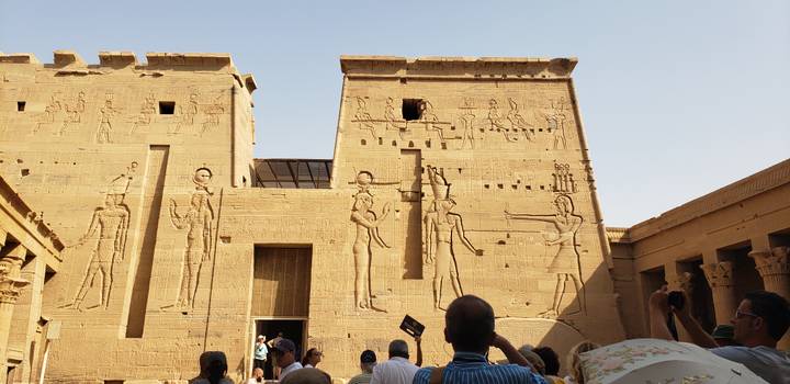 Historischer hieroglyphenbedeckter Tempel mit Touristen, die Fotos machen.