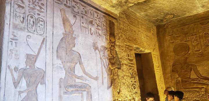 Inneres eines Tempels mit kunstvollen Hieroglyphen und Besuchern.