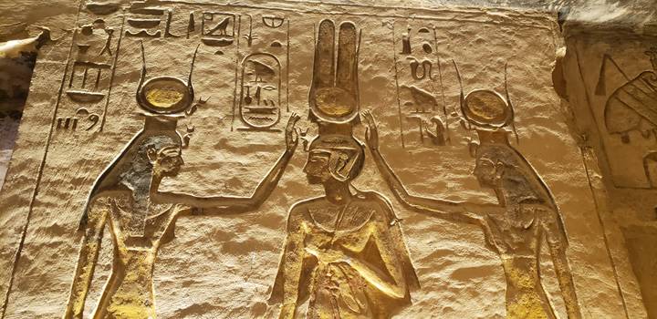 Kunstvolle Schnitzereien von Figuren und Hieroglyphen an einer Tempelwand.