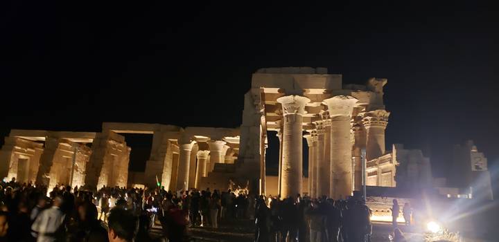 Nachtansicht eines antiken Tempels mit beleuchteten Säulen.