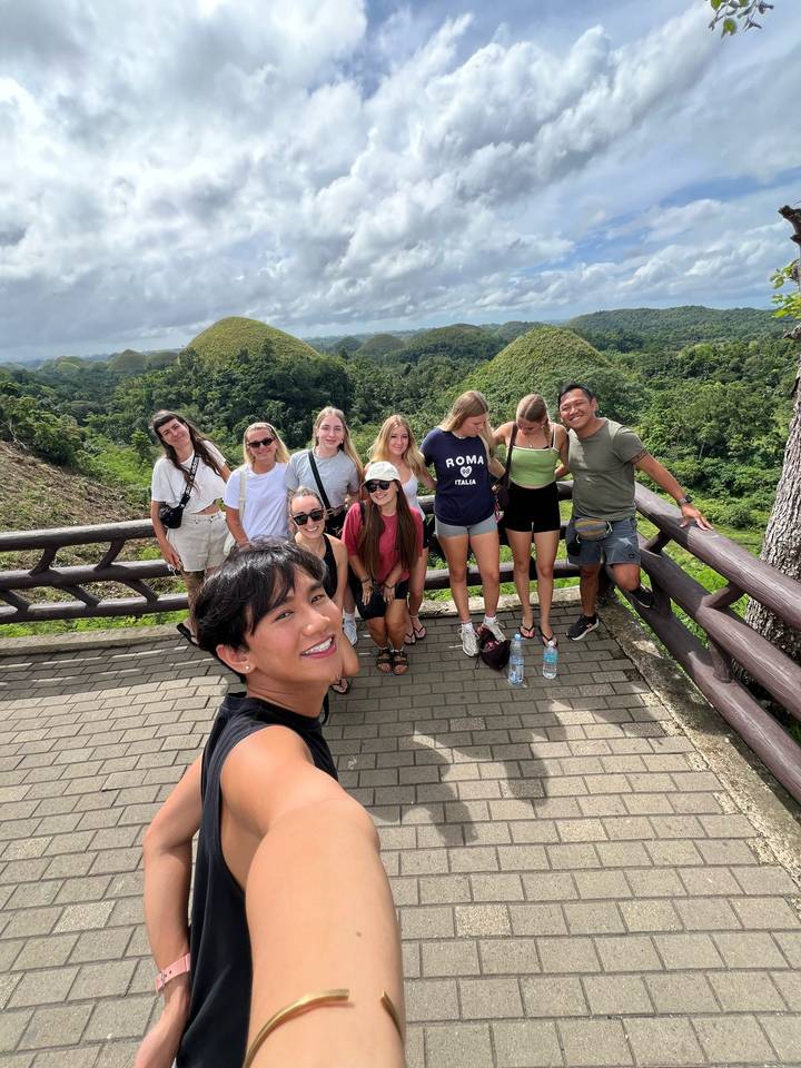 Gruppenfoto mit den Chocolate Hills im Hintergrund.
