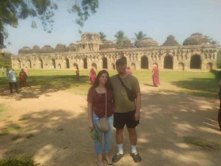 Couple debout devant un complexe de temples anciens.