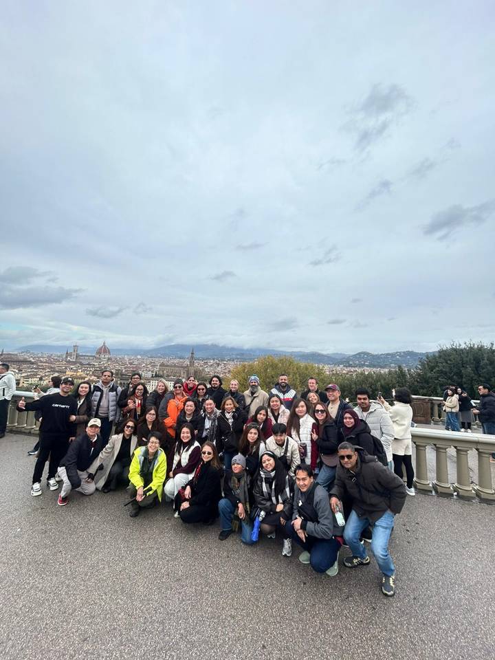 Große Gruppe von Touristen mit Stadtblick im Hintergrund.