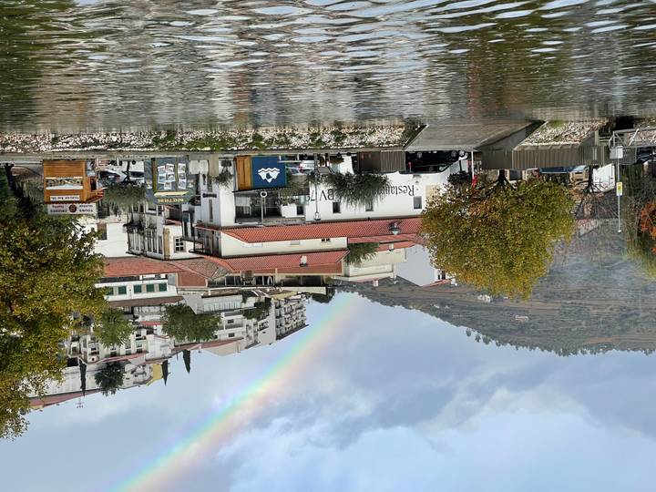Rivierstadje met regenboog aan de hemel.