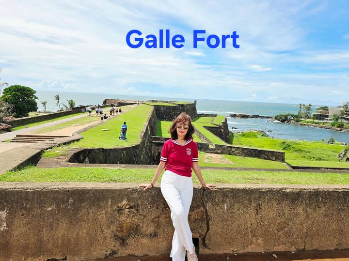 Een vrouw die poseert bij Galle Fort met overlay-tekst bovenaan.