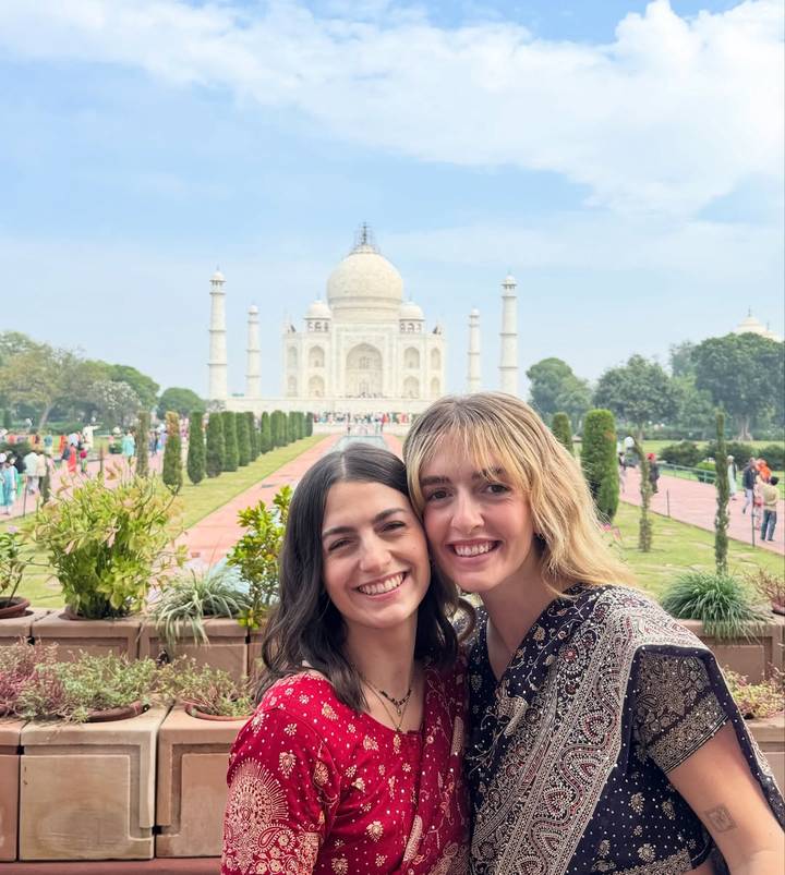 Two people smiling with the Taj Mahal in the background.
