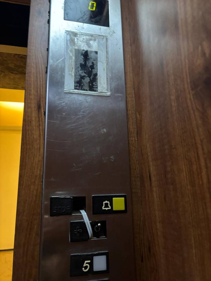 Elevator button panel with scratches.