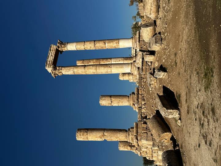 Colonnes en ruines d'un site historique sous un ciel bleu dégagé.