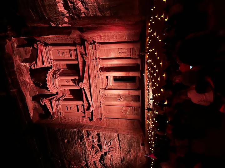 Façade du trésor de Pétra illuminée la nuit avec un public assis.