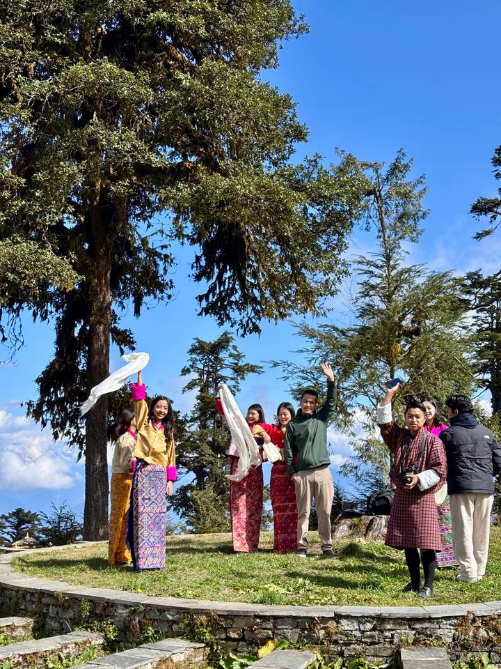 Grupo de personas en vestimenta tradicional saludando.