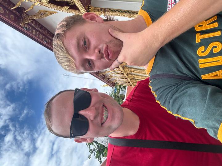 Dos personas tomándose una selfie al aire libre con un cielo despejado.