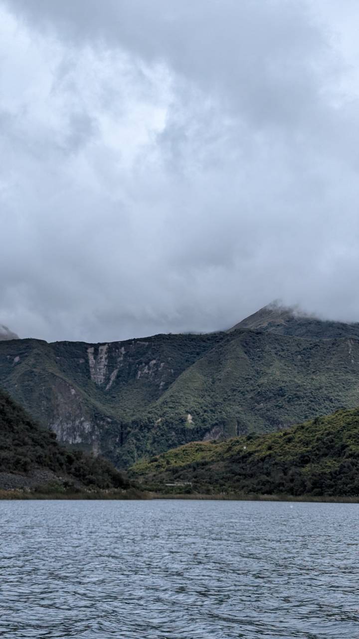 Collines et montagnes sous un ciel nuageux.