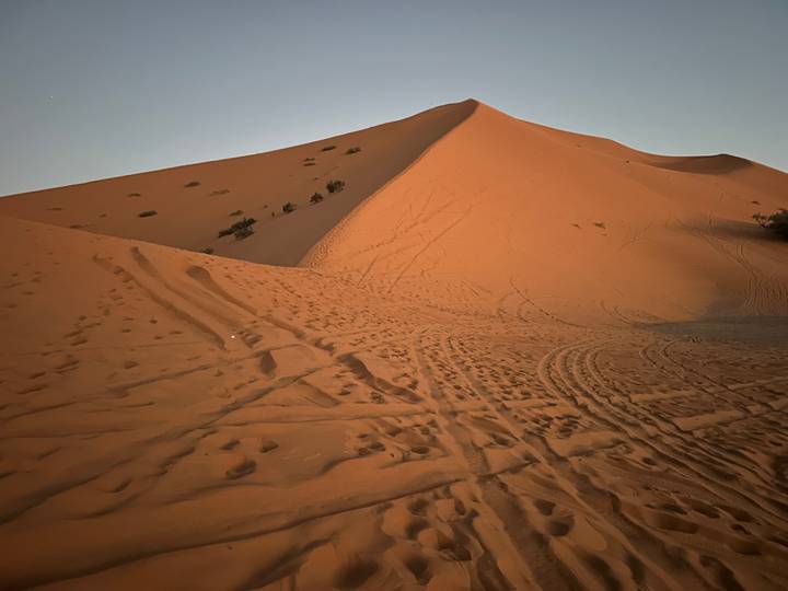 Paisaje de dunas de arena con huellas.