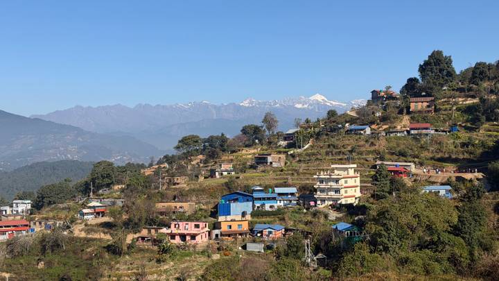 Bergdorf mit bunten Häusern und Bergkulisse.