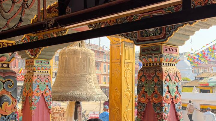 Kunstvoll verzierter Torbogen und Glocke in einem traditionellen Bereich.