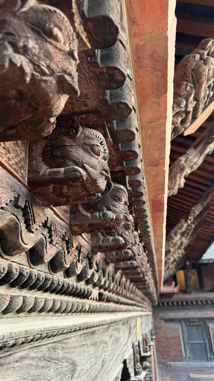 Nahaufnahme von kunstvollen Holzschnitzereien an einem traditionellen Gebäude.