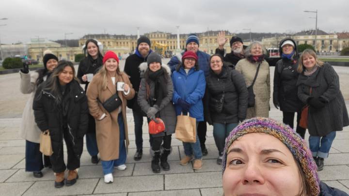 Gruppe von Touristen, die in Winterkleidung vor einem historischen Gebäude posieren.