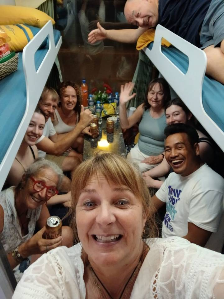 Gruppe von Menschen, die eine ungezwungene Mahlzeit in einem Zugabteil genießen.