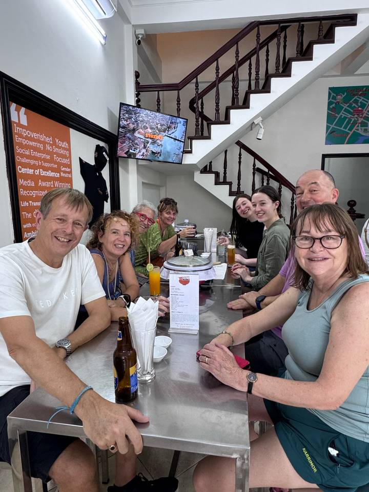 Gruppe von Touristen, die in einem Restaurant mit lokalem Ambiente speisen.