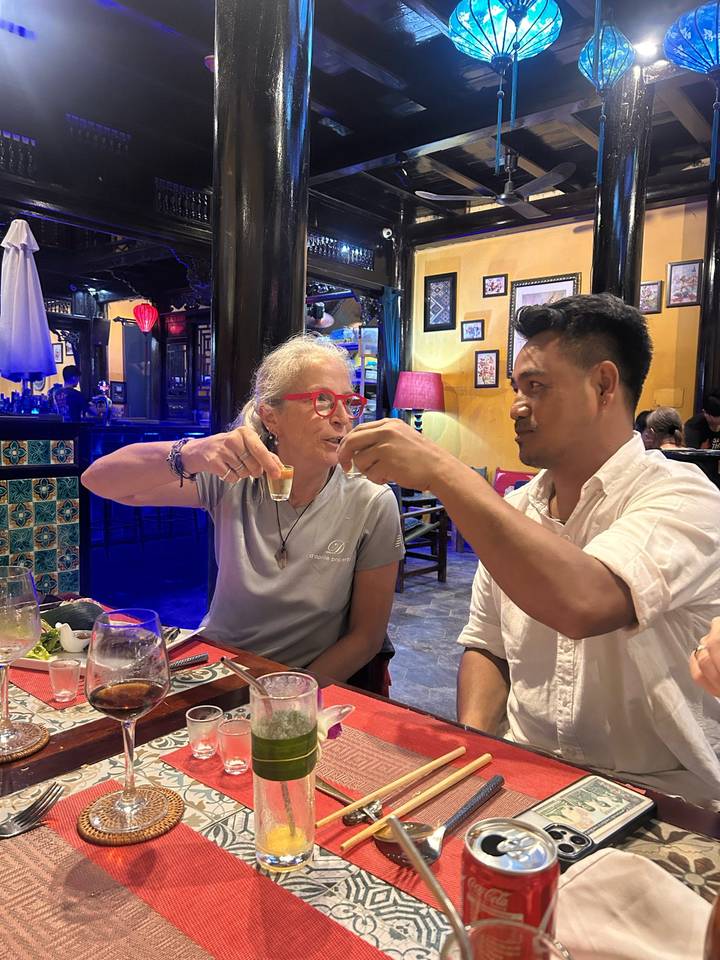 Zwei Personen stoßen in einem gemütlichen, lebendigen Restaurant an.