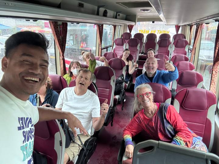 Fröhliche Gruppe von Touristen, die in einem Bus sitzt und einen regnerischen Tag genießt.