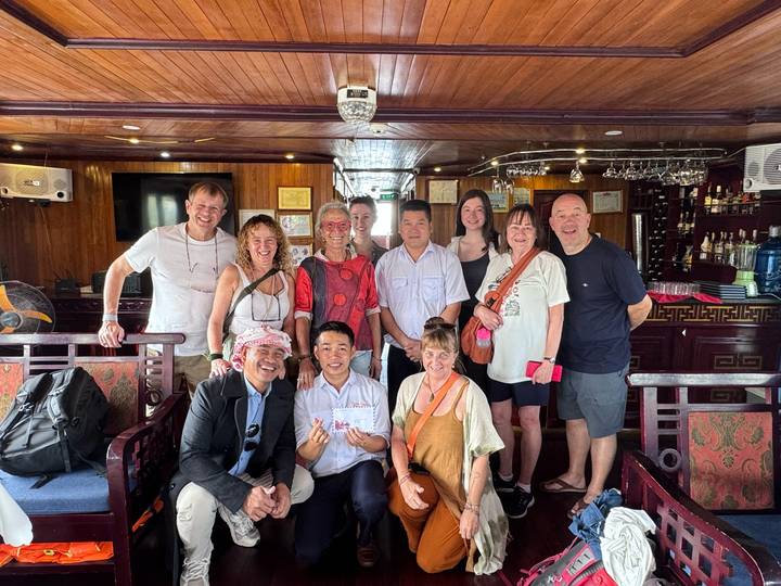 Gruppe von Touristen, die in einem Boot mit gemütlichem Interieur posieren.