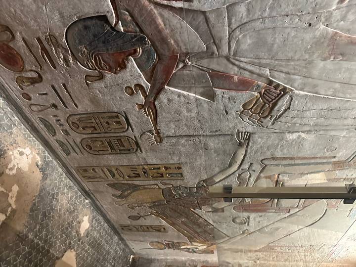 Muro de piedra tallada con jeroglíficos y figuras.