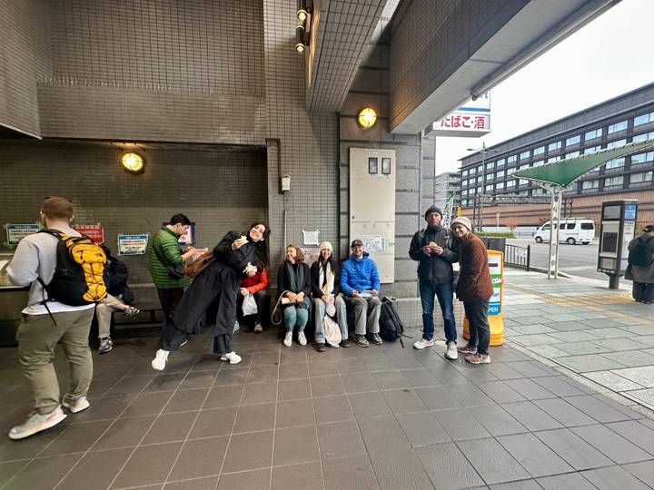 Des gens assis par terre dans une station de transport public.