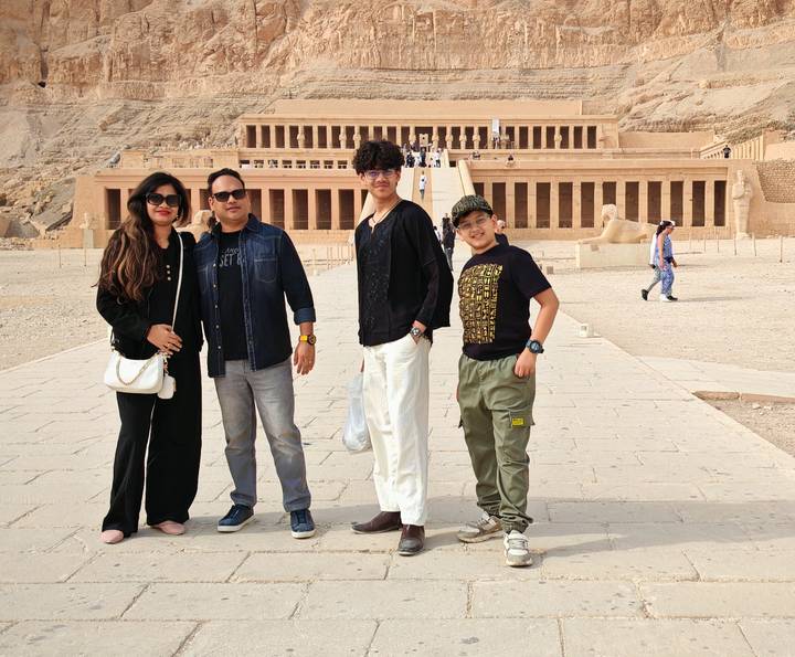 A family posing in front of an ancient Egyptian temple.