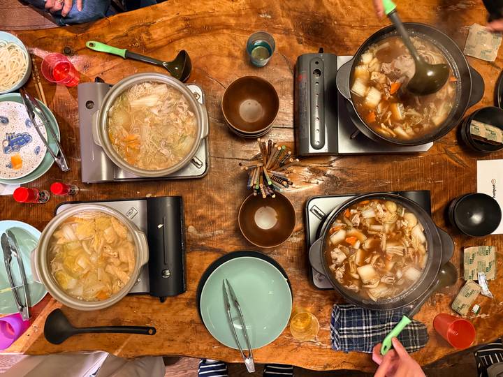 Variété de plats de fondue chinoise sur une table en bois.