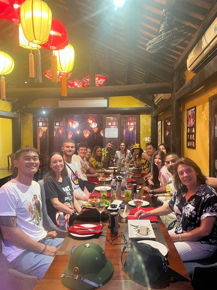 Große Gruppe speist zusammen in einem Restaurant mit Laternen.
