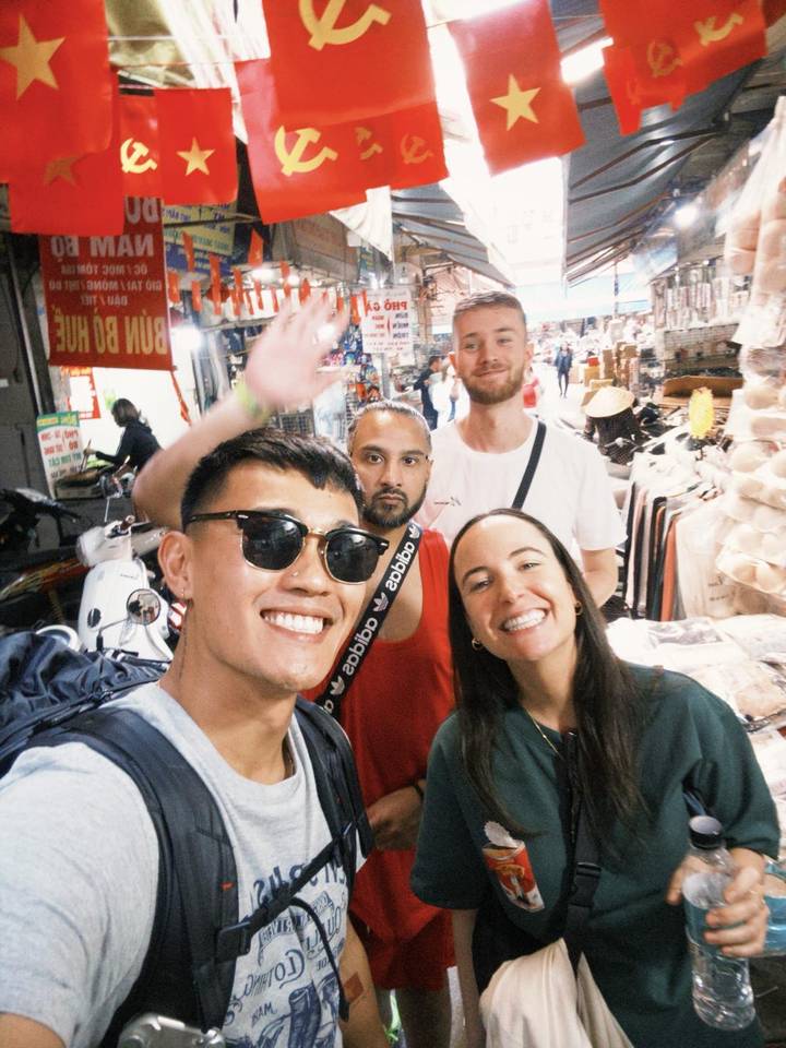 Gruppe von Menschen, die auf einem vietnamesischen Marktplatz lächeln.