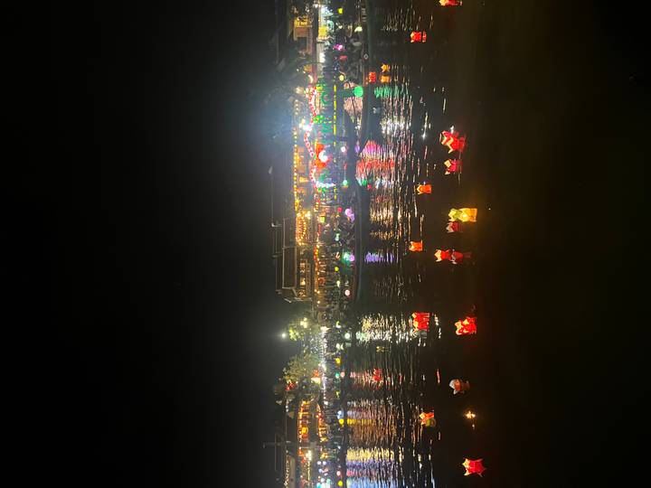 Laternen, die nachts mit leuchtenden Lichtern auf einem Fluss treiben.