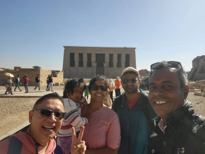 Gruppe von Menschen, die vor einer Tempelstruktur posieren.