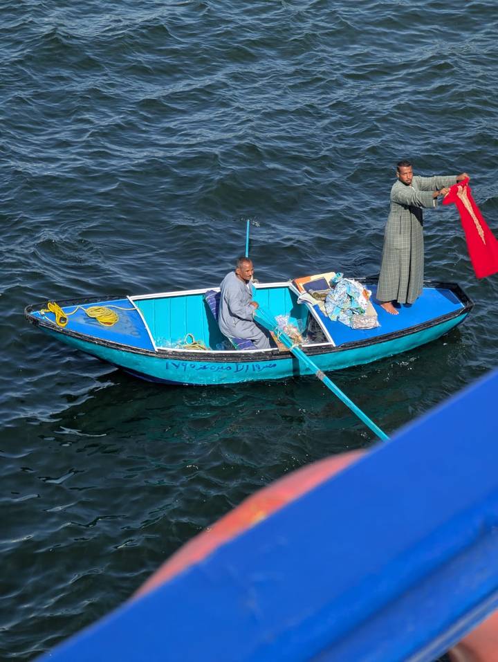Person, die ein kleines Boot in einem Fluss rudert.