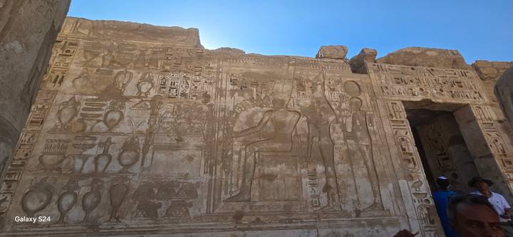 Gruppe beobachtet Wandschnitzereien an einem Tempel.