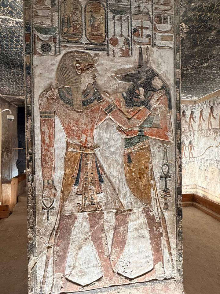 Grabados de dos figuras en una pared antigua.