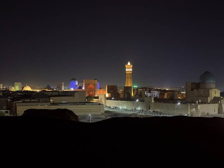 Vue nocturne d'une ville avec une architecture et des monuments illuminés.