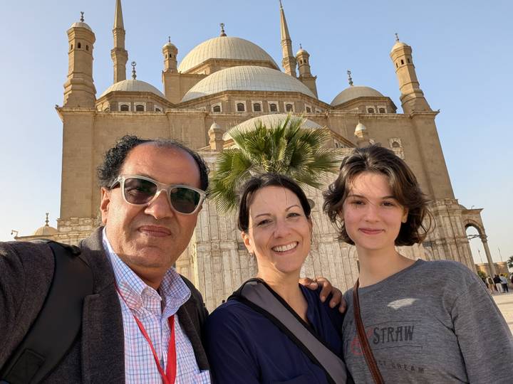 Group taking a selfie in front of a large mosque.