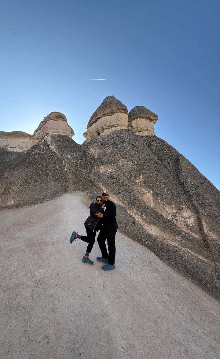 Pareja posando frente a formaciones rocosas únicas.