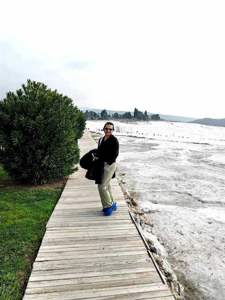 Persona caminando en un malecón con fondo de calcita blanca.