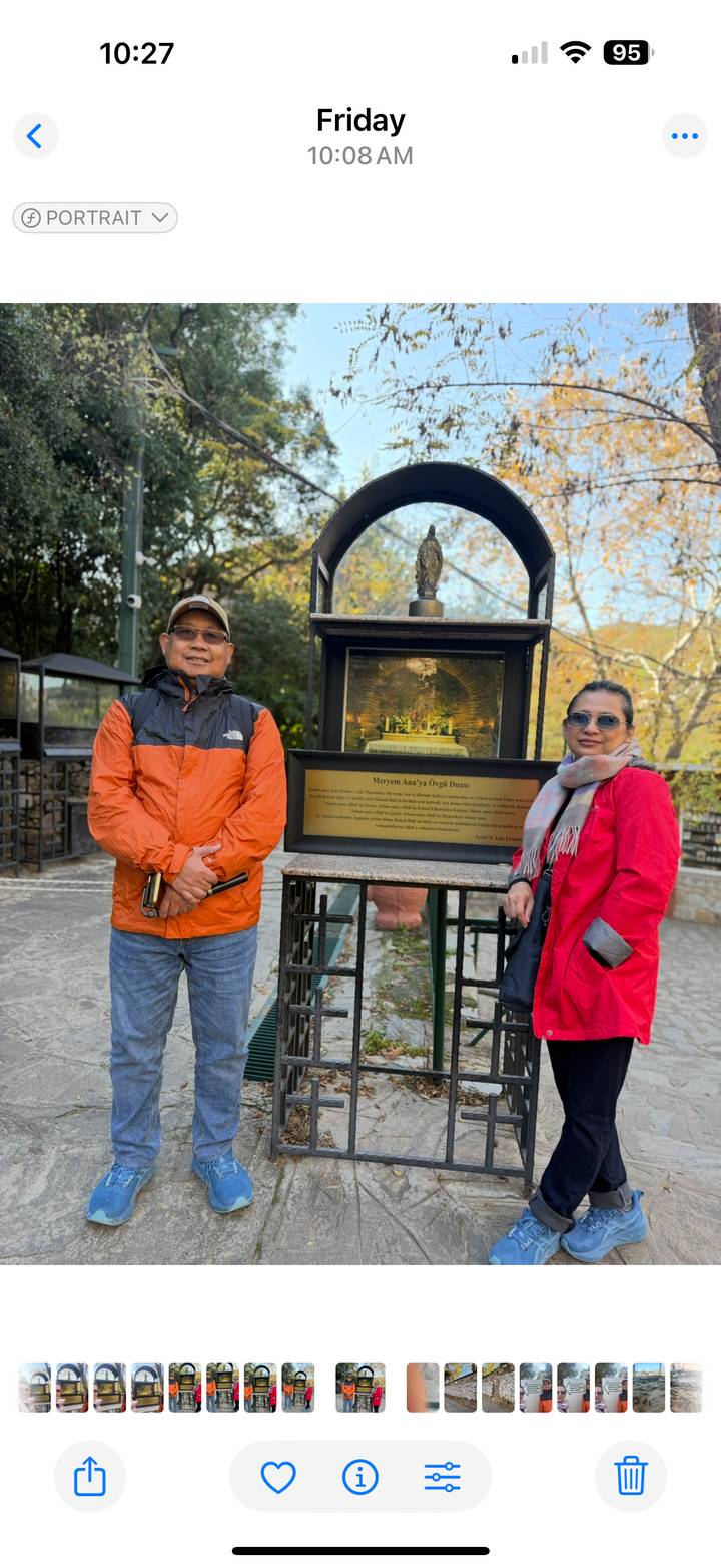 Dos personas con chaquetas coloridas paradas frente a una exhibición histórica.