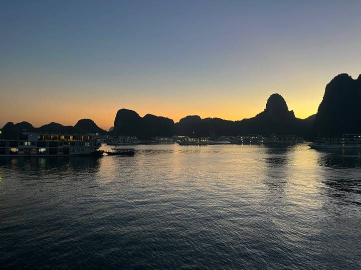 Boote in der Halong-Bucht während des Sonnenuntergangs.